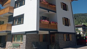 Um edifício com várias andares, varandas, uma placa com a inscrição 'Villa Maria' e uma antena parabólica.