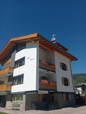 Un edificio de varios pisos con balcones, un cartel que dice 'Villa Maria' y una antena parabólica.