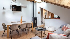 Un interior modern amb zona de menjador, sofà i escala que condueix a la cuina.