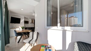 A modern apartment with a dining area, a living space with a view, and a kitchen. - Apartment "Refugio del Mar" with Sea View, Shared Pool & Wi-Fi (El puerto de santa maria)