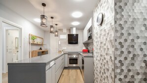 A modern kitchen with a central island, built-in oven, microwave, and stainless steel appliances.