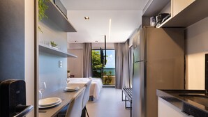 A modern hotel room with a dining area, a kitchen, and a balcony with a view. - Way Bossa por Carpediem (João Pessoa)