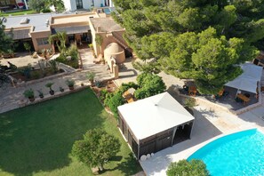 A resort with a swimming pool, outdoor seating, and a covered area.