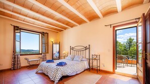 Une chambre à coucher avec un lit, une fenêtre, un balcon et une porte.