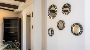 A room with a glass table, metal-framed chairs, a dark bookshelf, and four wall-mounted mirrors. - Apartment 'Can Roses' with Private Terrace, Wi-Fi and Air Conditioning (Moscari)