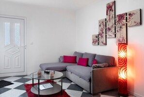 A modern living room with a sectional sofa, a glass coffee table, and a floor lamp.
