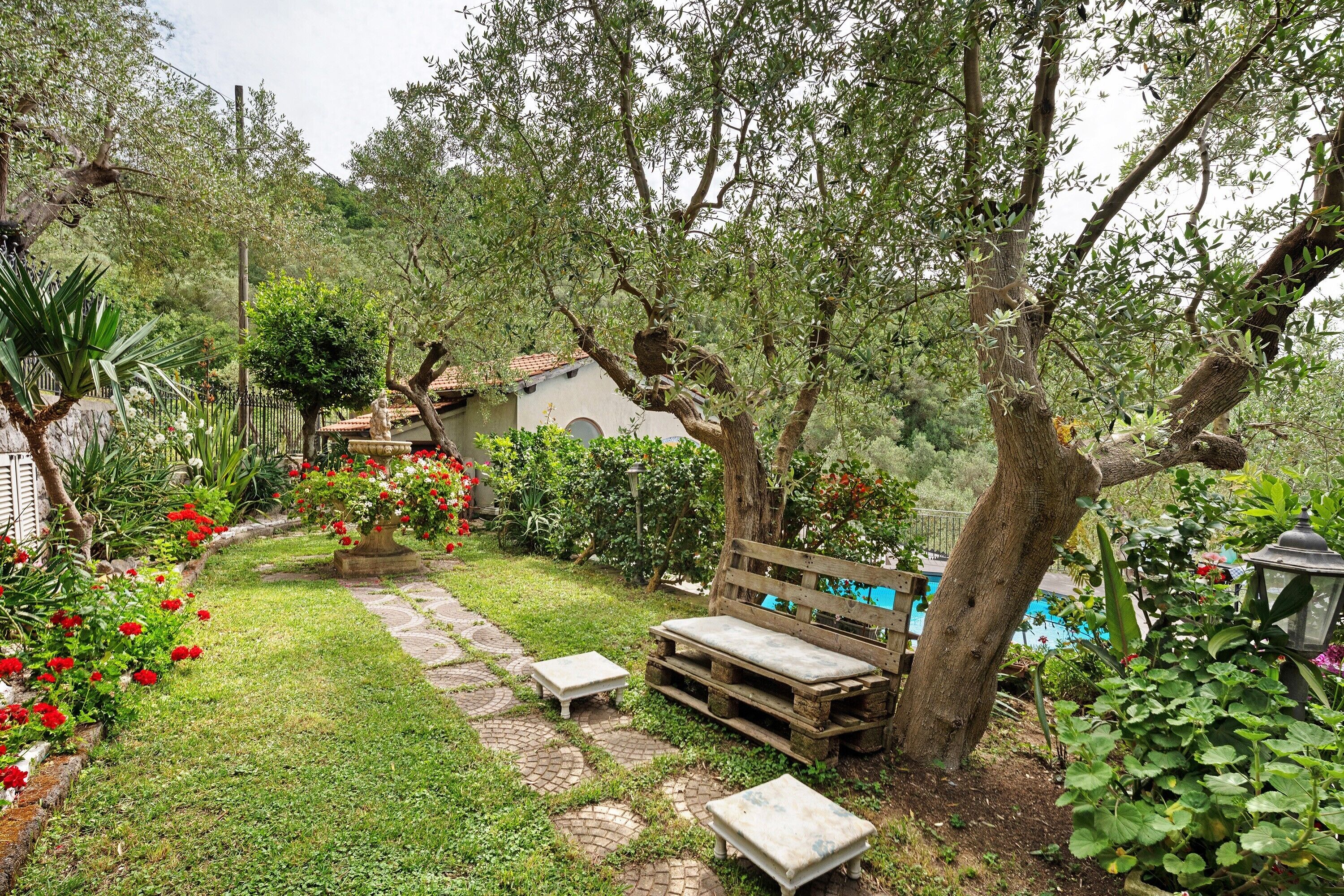 A garden with a bench, a small table, and a pathway.