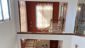 Ein mehrgeschossiges Interieur mit Treppe, einer Couch und einem Feuerlöscher.