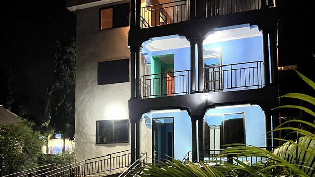 A multi-story building with balconies and a staircase leading to the entrance. - Kilimanjaro Smiley Inn (Moshi)