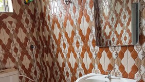 A bathroom with a toilet, a sink, and a mirror. - Kilimanjaro Smiley Inn (Moshi)