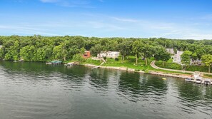 A lakeside view with boats, a dock, and houses along the shore. - Moonglade on Lake Carlos (Alexandria)