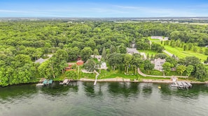 A lakeside property with multiple houses, a dock, and a golf course. - Moonglade on Lake Carlos (Alexandria)