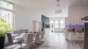 Eine moderne Küche mit weißen Schränken, einer schwarzen Arbeitsplatte und einer blauen LED-Leuchtleiste.