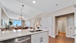 A spacious kitchen with a large island, stainless steel appliances, and a modern chandelier.