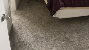Un dormitorio con una cama, una mesita de noche y una lámpara.