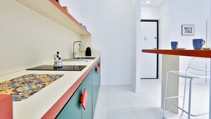 Una cocina moderna con un lavamanos, encimera y una silla.