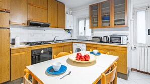 Una cocina compacta con armarios de madera, estufa, microondas y pileta.