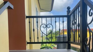 A staircase leading to a balcony with a black wrought iron railing and a heart-shaped design. - Charming 1-bedroom 1 bath apt. in awesome D'Abadie with AC, WiFi, Washer/Dryer. (D'Abadie)