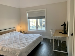 A bedroom with a bed, a desk, a chair, a lamp, and a window with blinds. - Cozy family home across the Blue Mountain South Lift, 1km to the Village. (The Blue Mountains)