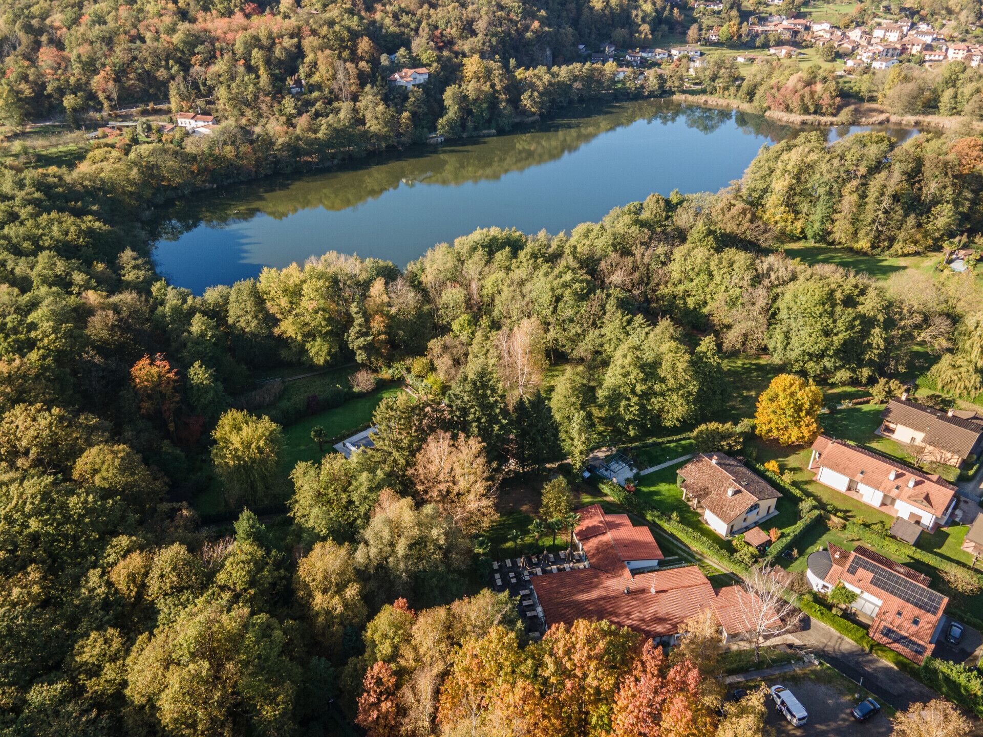 Vista aérea de una zona residencial con casas, un lago y vegetación circundante.