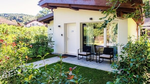 A small, single-story building with a patio area featuring two chairs and a table. - A barrier free studio apartment (LE BETULLE STUDIO 6) (Origlio)
