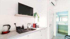 Cuina moderna amb televisió de pantalla plana, tetera, cafetera i rentamics.