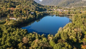Un lac entouré de collines boisées, avec un petit village situé à proximité.