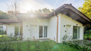 Een modern huis met een plat dak, grote ramen en een verzorgde tuin.