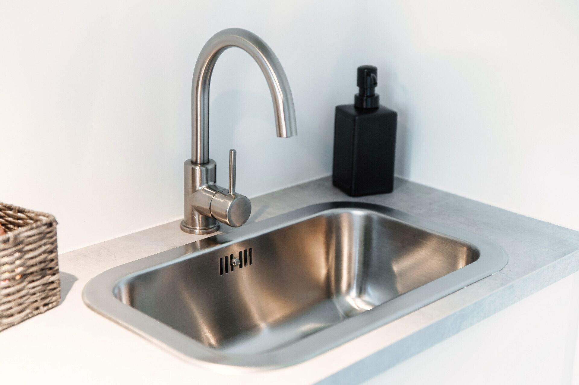 Lavello da cucina moderno con un rubinetto singolo e un erogatore di sapone.
