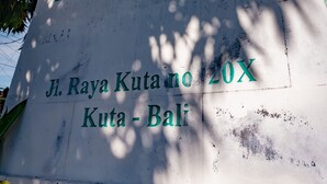 A sign with the text "PURI DEBIA" and "Jl. Raya Kuta no 20X Kota - Bali". - Puri Dibia Hotel (Kuta)