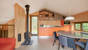 A modern kitchen with a central island, wooden cabinetry, and a built-in stove. - 3 bedroom awesome home in Spier (Spier)