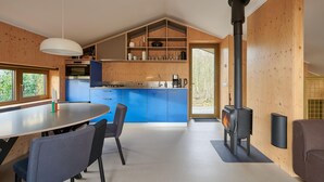 A modern kitchen with blue cabinets, a central island, and a wood-burning stove. - 3 bedroom awesome home in Spier (Spier)