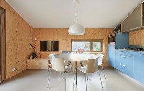 Enjoy meals in the kitchen and dining area with a round table and four chairs, a flat-screen TV, and a large window.