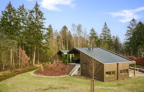 Situated in a forested area, this cabin offers a peaceful retreat with a sloped roof and entrance.