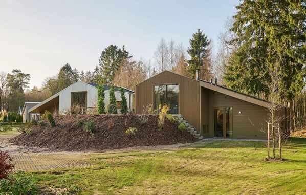 Set amidst a serene natural setting, this two-story residence offers a peaceful retreat with a well-manicured lawn and beautiful trees.