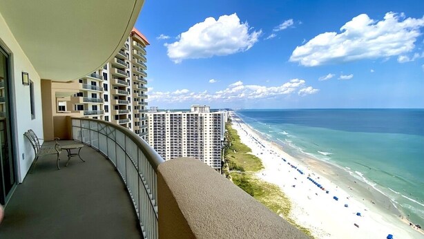 Un balcone con vista sulla spiaggia e su edifici alti.