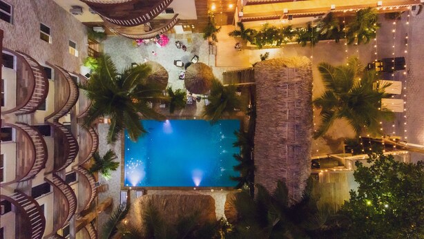 A rooftop pool with a clear view of the surrounding architecture, including a spiral staircase and palm trees. - Tropical Palace Hotel (San Pedro)