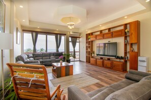 Familie penthouse | Woonruimte | Een 32-inch flatscreentelevisie met digitale zenders en betaalfilms