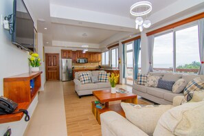 Familie penthouse | Woonruimte | Een 32-inch flatscreentelevisie met digitale zenders en betaalfilms