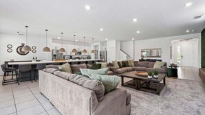 En moderne opholdsstue med sofa, sofabord og barområde.