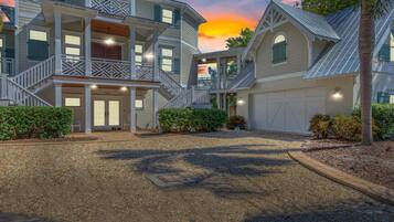 A large, multi-story house with a covered front porch and a driveway.