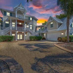 A large, multi-story house with a covered front porch and a driveway. - Serenity Cottage in Anna Maria (Anna Maria)