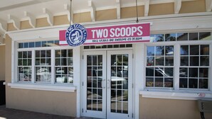A storefront with a sign reading "TWO SCOOPS" and a window display. - AM Island Beach To Bay Bliss (Bradenton Beach)