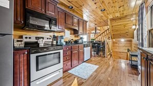 A kitchen with wooden cabinets, a stainless steel refrigerator, a double oven, and a microwave. - 3 Bedroom, Sleeps 10, Close to town w Pool, Hot Tub, Sauna and Game Room! (Sevierville)