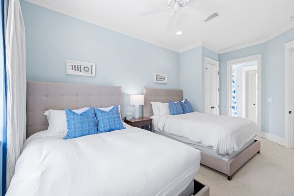 A hotel room with two beds, a ceiling fan, and light-colored walls. - Golf Cart, Carriage House, Beautiful Interior Watercolor Home (Santa Rosa Beach)