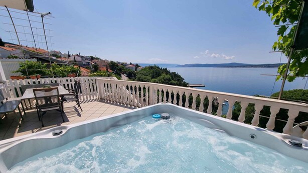 Uma banheira de hidromassagem com vista para um lago e edifícios ao redor.