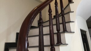 A wooden staircase with a curved handrail leading up to a landing. - Selene Home (Hanoi)