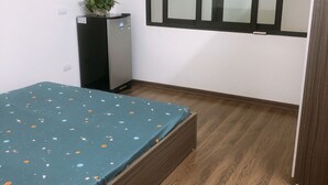 A small room with a bed, a desk, a cabinet, and a potted plant. - Selene Home (Hanoi)