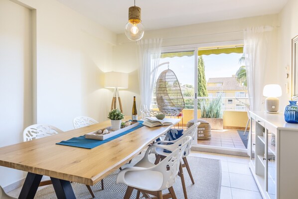Enjoy meals in this cozy dining area with a table for two, a wicker chair, and a view of the outdoors.