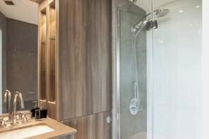 A modern bathroom with a glass shower enclosure, a wooden vanity, and a large mirror. - Fantastic Modern 2BD Flat in Centre (London)